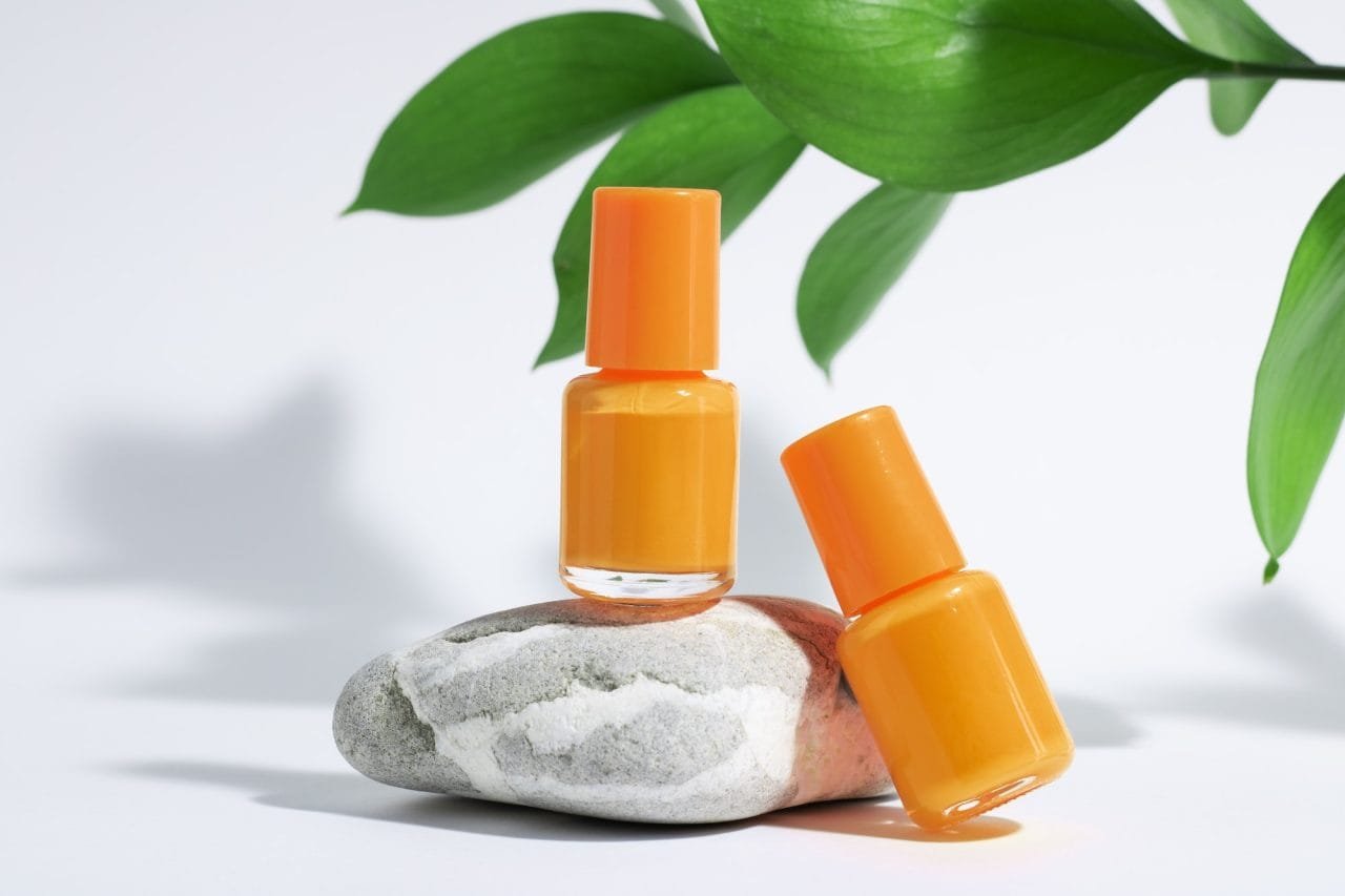 manicure or pedicure background creative mockup of isolated cosmetics bottles with orange.jpg